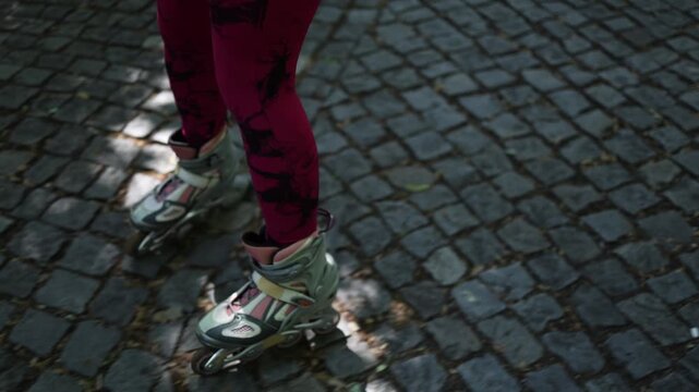 Close up of a woman struggling to skate over uneven cobblestones showing how poor urban surfaces make inline skating uncomfortable and physically demanding daily