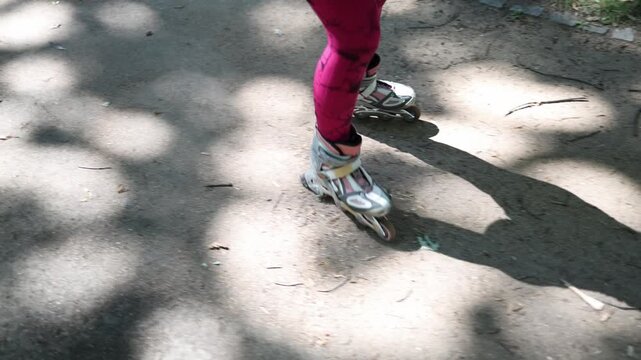 Close up of inline skates moving along a rough forest path because crowded cities often lack smooth safe places for comfortable roller skating practice outdoors