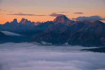 Breathtaking mountain landscape featuring rugged peaks emerging from a dense blanket of clouds at sunrise. Ideal for travel, adventure, and mindfulness themes © marcodenaro