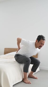 腰を押さえて痛がる50代の日本人男性