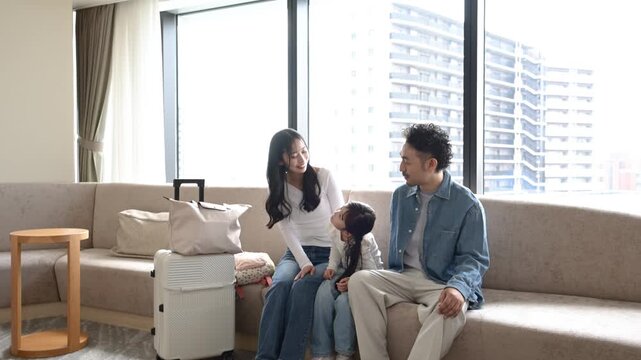 旅行先のラウンジで会話を楽しむ30代日本人夫婦と6歳の子ども