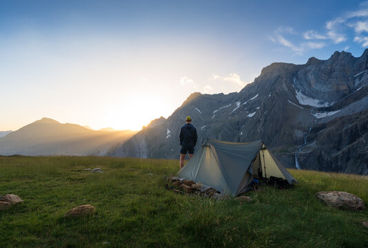 Hiker enjoying the sunrise at his bivouac in Cirque de Gavarnie.