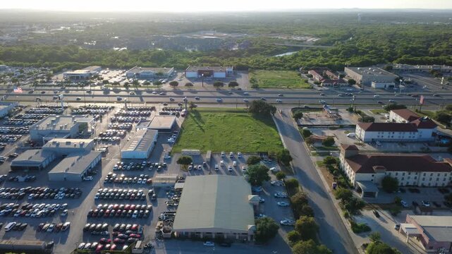 Commercial service centers border open green parcels in Alamo Downs Business Park along Loop 410 corridor. Hotel facilities sit across secondary access roads near Bexar County, San Antonio