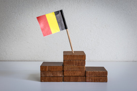 Belgian Flag Rising Above Wooden Steps Toward Success and Achievement