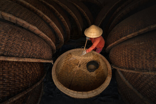 Vietnamese artisan weaving traditional bamboo coracle boat in Phu Yen province, Vietnam