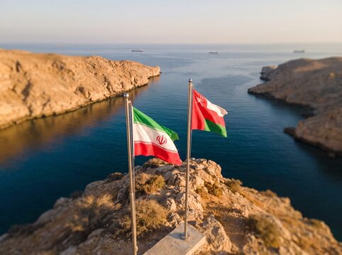 Iranian and Omani Flags Above Coastal Strait