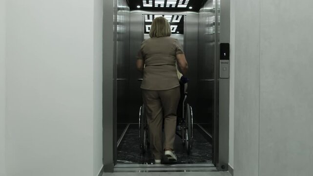 Patronage nurse helps person in wheelchair cross elevator threshold safely. Doctor helps woman reach sterile procedure room. Slow motion