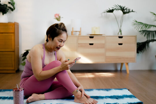 Mature female asian yoga home living room practice