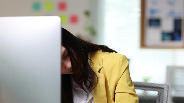 Businesswoman getting a headache working on computer. Stress and pressure from deadlines contribute to her frustration and fatigue.