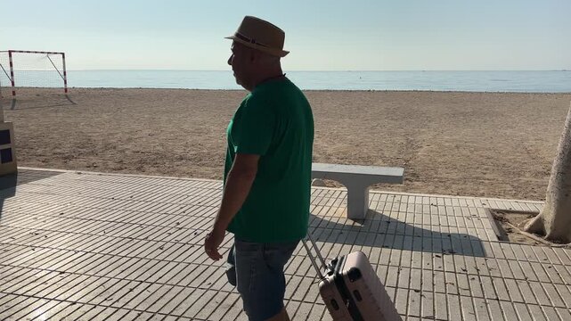 Hombre con maleta en paseo mar&iacute;timo de Altea, Alicante