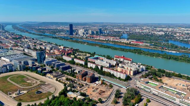 Aerial drone view of the Danube River and Donauinsel island with the Donau City skyline, DC Tower, Krieau racetrack and Messe Wien exhibition halls, Vienna, Austria, in summer.