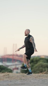 Tattooed man jumping rope during outdoor workout