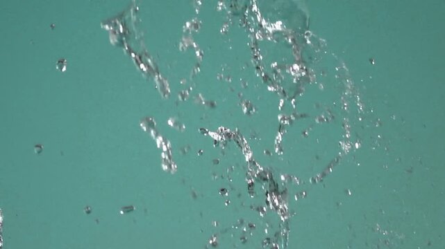 Dynamic water flushing through a rocky stream with splashing droplets and natural turbulence.