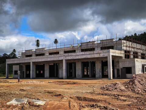 Large Concrete Structure Under Construction Featuring Scaffolding Against A Cloudy Sky During A Rural Building Project