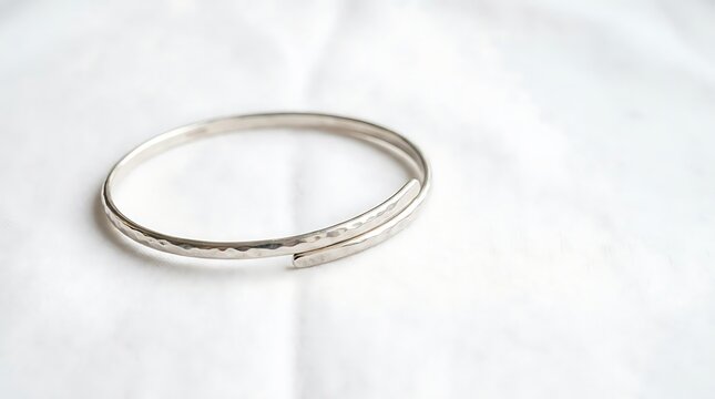 Elegant Hammered Sterling Silver Wrap Bangle Bracelet on White Soft Textured Fabric Background