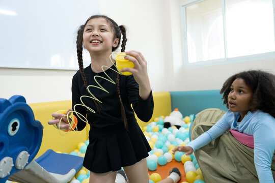 Girl playing with spring toy in ball pit