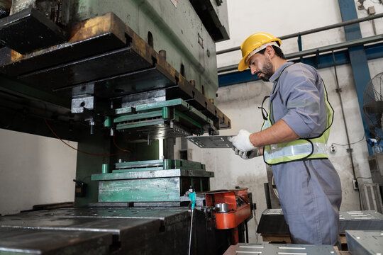 Industrial workers working and control machine at auto parts factory