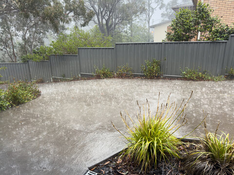 Extremely heavy rain splashing and running like a river down a concrete driveway