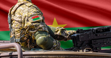 Fototapeta premium Burkina Faso flag with soldier at machinegun turret