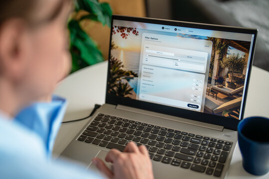 Woman setting search filters on travel booking website via laptop.