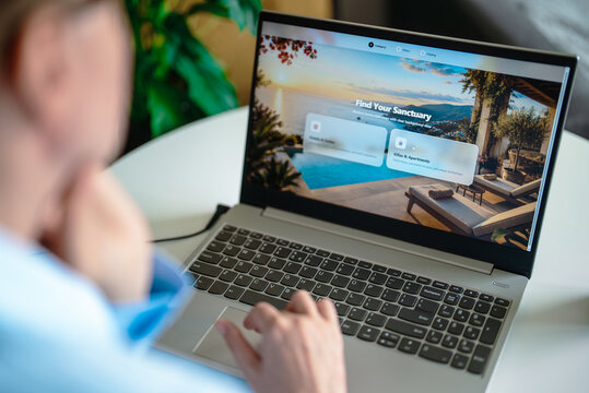 Woman choosing resort category on travel website via laptop.