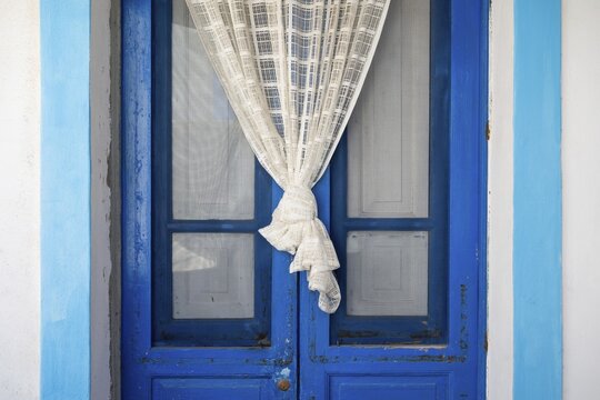 Blue and white front door, white curtain, Malfa, Salina, Aeolian or Lipari Islands, Southern Italy, Italy