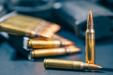 Rifle ammunition bullets on stripper clips with weapon background. Real photograph, not AI-generated © TimeStopper