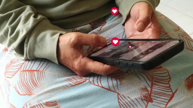 Person using a smartphone to interact with social media content with heart and like icons.