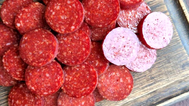 Slices of smoked pepperoni or salami for making homemade pizza. Sliced pepperoni as a food background for your design