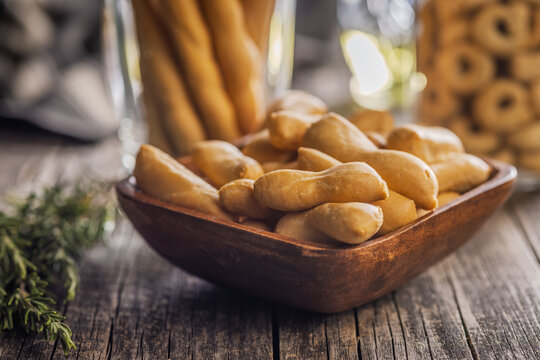 Rustic Breadsticks And Bite-Sized Savory Snacks In Wooden Bowl On Weathered Table