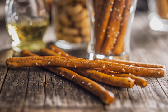 Salted Pretzel Sticks On Rustic Wooden Table With Glass Jar And Warm Lighting