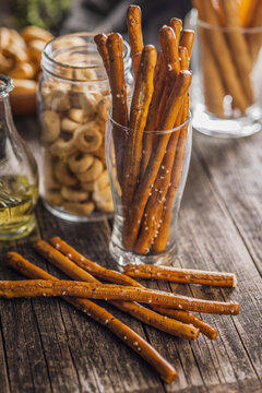 Salted Pretzel Sticks On Rustic Wooden Table With Glass Jar And Warm Lighting