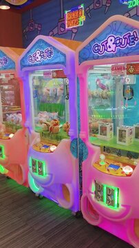 Colorful claw machines light up with changing hues in arcade game zone