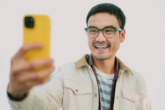 dult asian man using mobile, cell phone.portrait young male person posing smart phone smiling laughing look fun excited surprised happy.empty space for text advertising