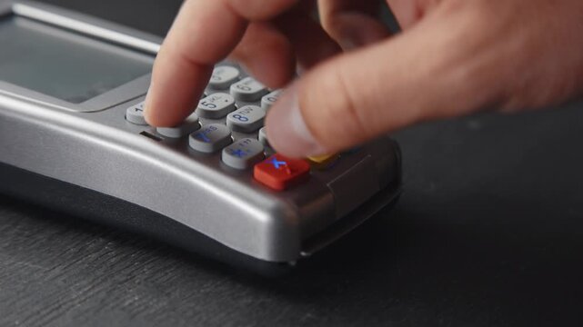 Unrecognizable person pushing the button and swipe credit card for payment on modern electronic terminal for secure retail shopping transaction in 4K Ultra HD footage
