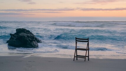 Empty chair on the Atlantic Ocean coast at sunset in Portugal © Olga