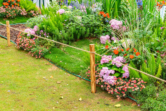 Pile of sharp wood, wooden fence posts in flower garden