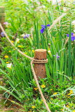 Pile of sharp wood, wooden fence posts in flower garden