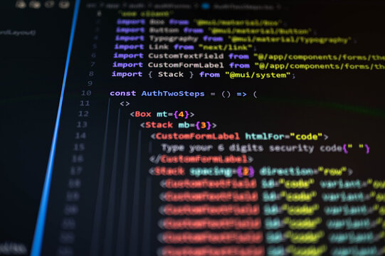 Close-up of source code displayed on a computer monitor with colorful syntax highlighting and shallow depth of field, representing software development, web programming, cybersecurity, coding.
