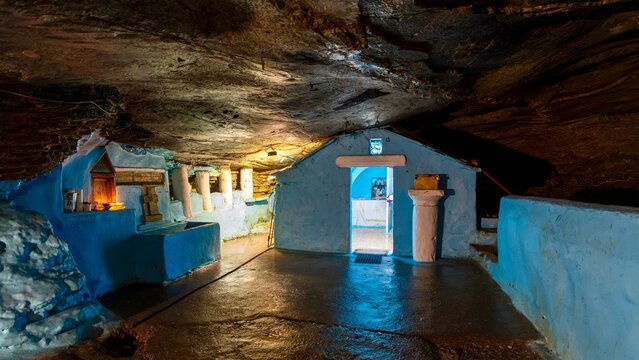 Pythagoreio, Greece - August 1, 2026: Interior view of the cave chapel at Panagia Spiliani Holy Monastery, featuring natural rock formations, a small Greek Orthodox church, and religious details