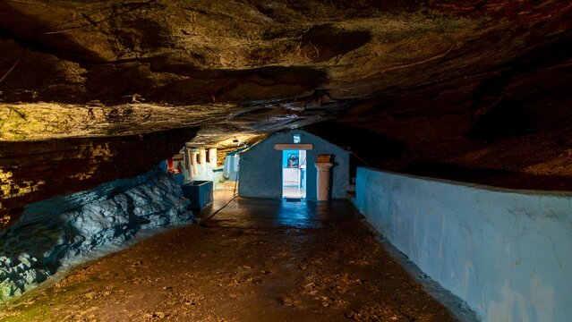 Pythagoreio, Greece - August 1, 2026: Interior view of the cave chapel at Panagia Spiliani Holy Monastery, featuring natural rock formations, a small Greek Orthodox church, and religious details