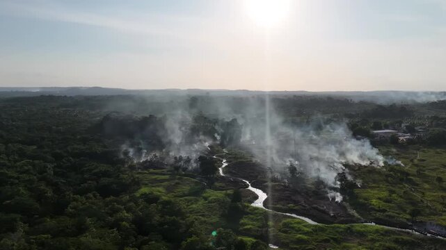 A panoramic view at sunset of several fires producing a thick column of smoke and deforestation in the Amazon rainforest.