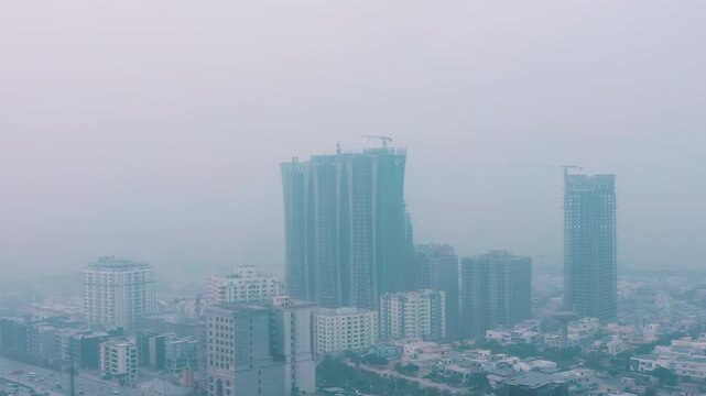 A panoramic view of buildings in a city completely polluted by smog, a serious consequence of climate change and the climate crisis.