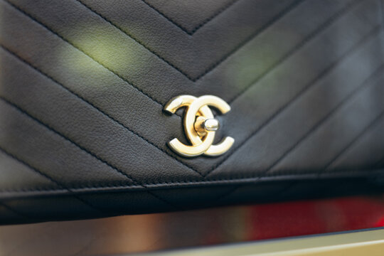Nice, France - July 27, 2026: Close-up of a black Chanel handbag with gold CC logo displayed in a vintage boutique window on Avenue de Suede