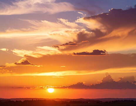 A breathtaking, vibrant sunset sky filled with glowing orange clouds and golden evening light over a dark horizon evokes peace and tranquility. Perfect background with no people.