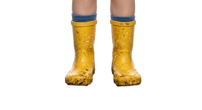 Child's muddy yellow rubber boots with blue socks ready for outdoor adventures