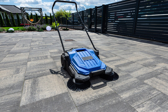 Manual sweeper cleaning outdoor paving slabs driveway