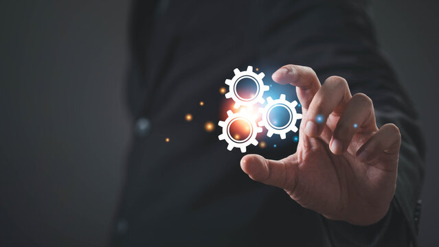 Business professional interacting with digital gears, representing business process automation, workflow optimization, system integration, operational efficiency, digital transformation, innovation.