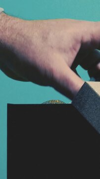 Removing wrapping ribbons from a gift box on a blue background before the holiday