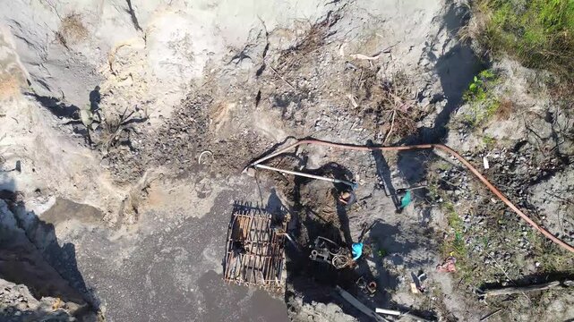 Artisanal Tin Mining Activity with Workers Using Water Spray Equipment